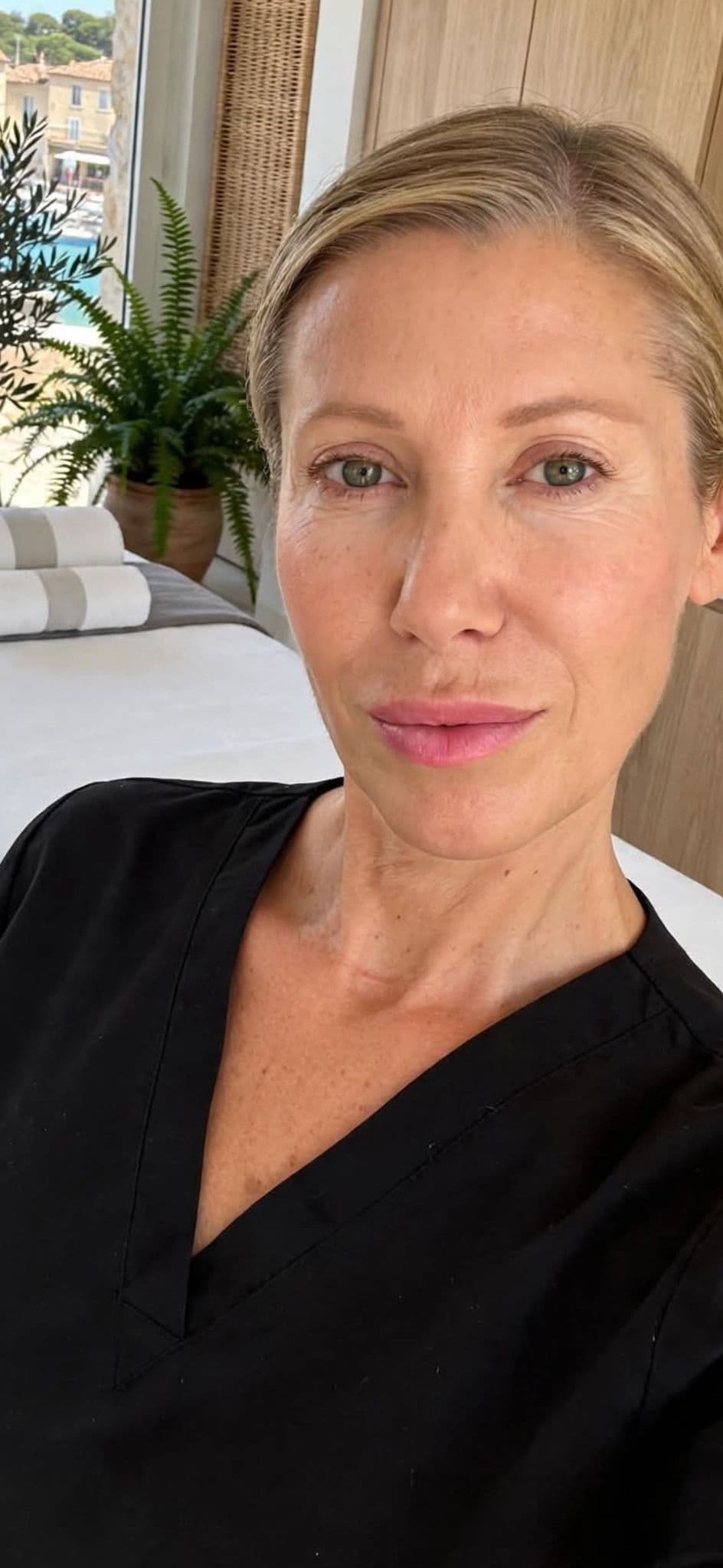 Portrait de Cristina Keller dans le studio d'Antibes, table de massage et vue sur le port en arrière-plan